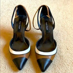 High-heeled black, white, and tan shoes